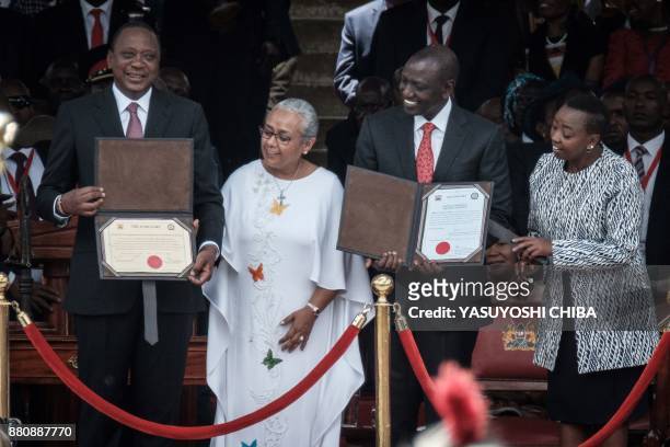 Kenya's President Uhuru Kenyatta and Vice-President William Ruto hold certificates during the inauguration ceremony at Kasarani Stadium in Nairobi,...