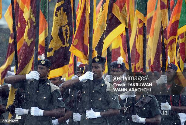 Sri Lankan army soldiers walk with the national flag as they take part in rehearsals for The National Military Victory Celebration in Colombo on June...