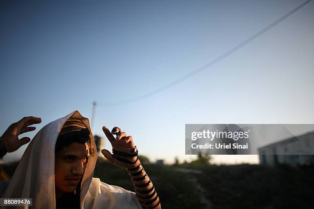 Jewish settler prays at the Ramat Gilad outpost, as Jewish settlers prepared for a possible evacuation by Israeli police early morning, on June 01,...