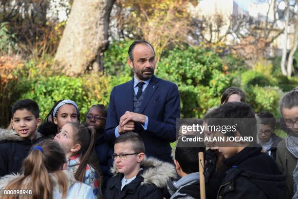 French Prime Minister Edouard Philippe prepares to plant an apple tree with pupils from the primary school of Theophile Gautier in le Havre, in the...