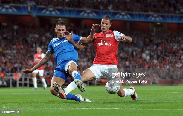 Marouane Chamakh of Arsenal and Jose Holebas of Olympiacos battle for the ball during a UEFA Champions League match at the Emirates Stadium on...