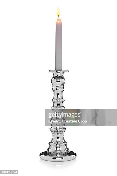 heavy chrome candlestick with a light white candle - candle holder stock pictures, royalty-free photos & images