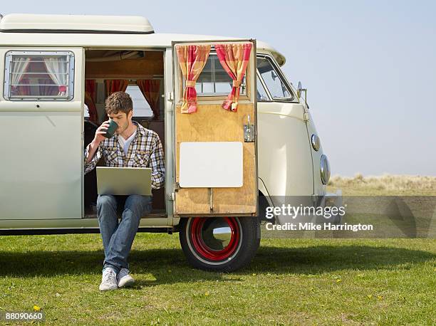 man with laptop in camper van - vehicle door stock pictures, royalty-free photos & images