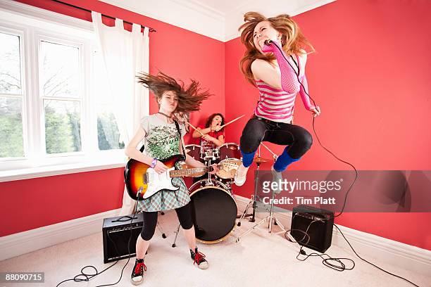 three young girls playing in a rock band - playing drums fotografías e imágenes de stock