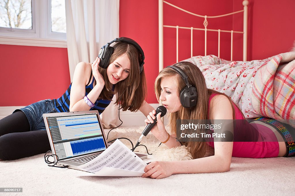 Young girls recording music to a laptop