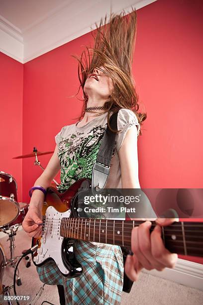 young girl playing electric guitar - playing electric guitar stock-fotos und bilder