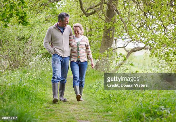 couple walking along country path. - age 55 health stock pictures, royalty-free photos & images