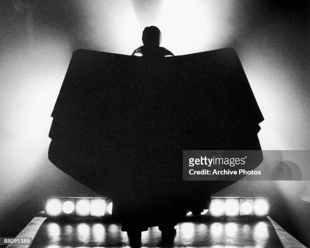 The silhouetted figure of the vampire Count Dracula, raising his cape in batlike-fashion, circa 1970.