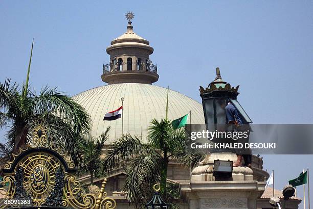 Workers cleans a lamp at Cairo University on June 1, 2009. Beneath the century-old university's dome, US President Barrak Obama will deliver a...