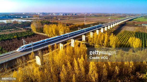 Train runs on the Xi'an-Chengdu High-Speed Railway at a viaduct on November 25, 2017 in Guanzhong Plain, Shaanxi Province of China.