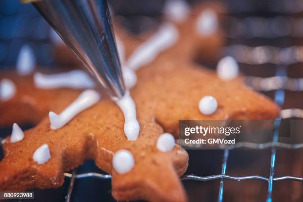 decorating gingerbread cookies with icing - icing stock pictures, royalty-free photos & images