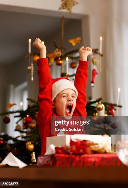 boy opening christmas presents - child christmas stock-fotos und bilder