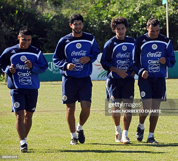 Footballers Rodrigo Rojas, Pedro Benitez, Cristian Riveros and Julio Manzur jog during a training session of the Paraguayan national team in Luque,...
