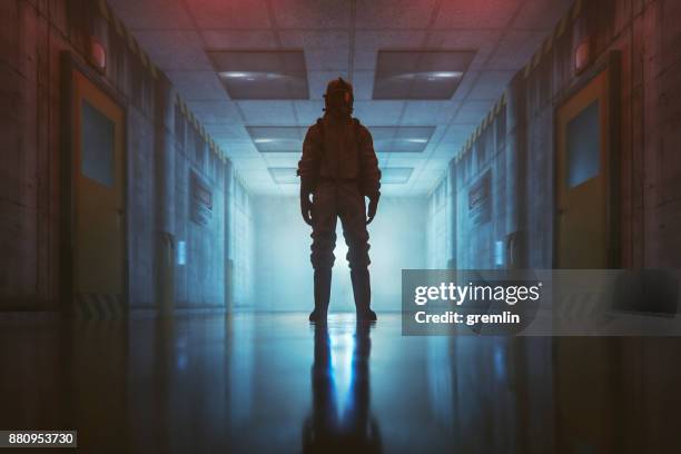 secret government underground facility with standing man in hazmat suit - military bunker stock pictures, royalty-free photos & images