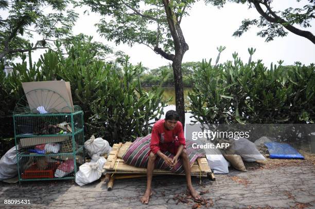 Displaced Bangladeshi villager waits with his belongings on a street on the outskirts of Khulna some 400 kms from Dhaka on June 1, 2009. Bangladesh...