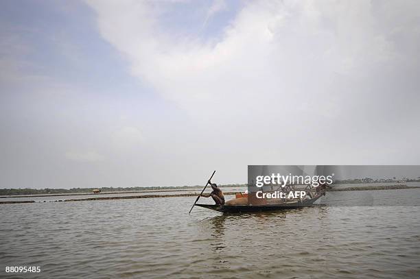 Displaced Bangladeshi villagers carry their belongis on a boat as their homes were flooded on the outskirts of Khulna some 400 kms from Dhaka on June...