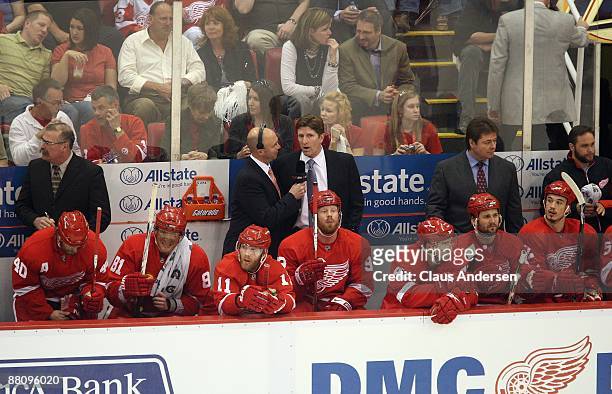 Head Coach Mike Babcock of the Detroit Red Wings is interviewed during a stoppage in play by Pierre McGuire against of the Chicago Black Hawks during...