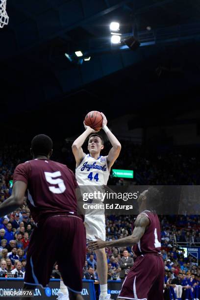 Mitch Lightfoot of the Kansas Jayhawks shoots against Donte Clark of the Texas Southern Tigers and Trayvon Reed of the Texas Southern Tigers at Allen...