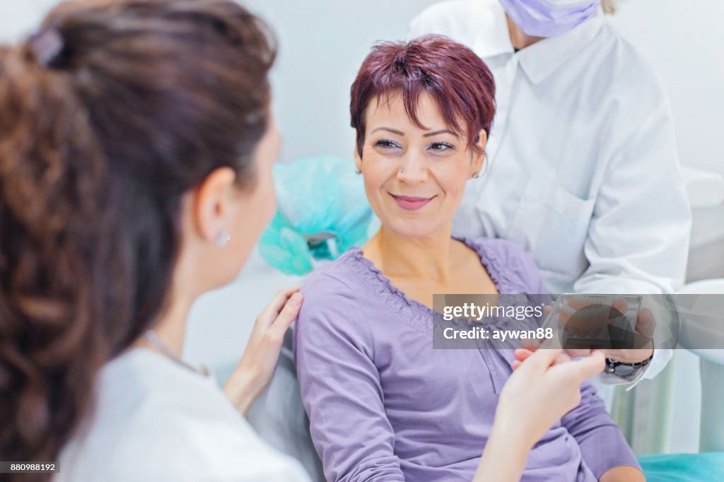 Dentist showing teeth dentures to a patient