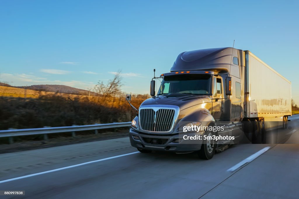 18 wheeler semi truck on road at sunrise