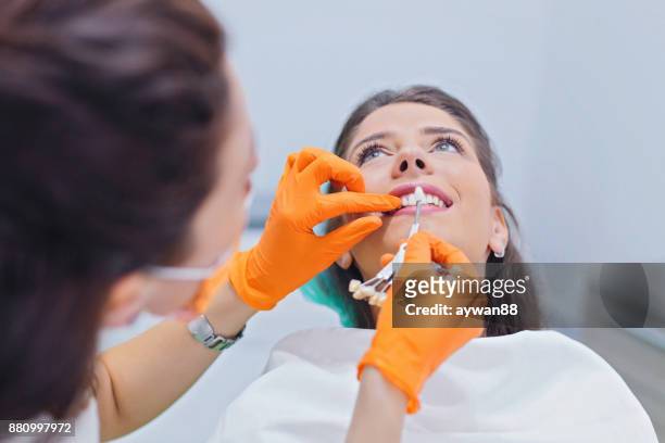 tandläkare väljer färg på tänderna - pick tooth bildbanksfoton och bilder