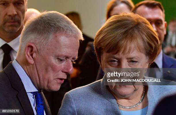 German Chancellor Angela Merkel talks with Stuttgart's mayor Fritz Kuhn on the sidelines of a press conference following a so-called "Diesel Summit"...