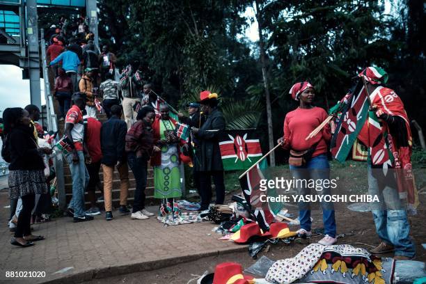 People sell Kenyan flags and goods for participants who participate in Kenya's President inauguration ceremony at Kasarani Stadium in Nairobi on...