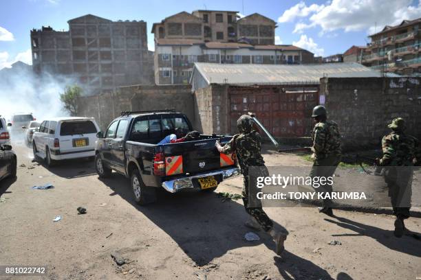 An anti-riot policeman wields a baton against members of opposition leader's entourage, who had taken cover in one of the convoys vehicles to escape...