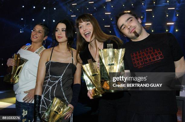 Les chanteuses Diam's, Emilie Simon, et Carla Bruni posent aux côtés du batteur du groupe Kyo Fabien Dubos avec leurs victoires, le 28 février 2004 à...