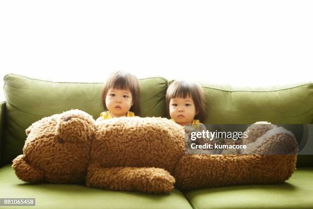 twin little sisters and big teddy bear - asian twins stock pictures, royalty-free photos & images