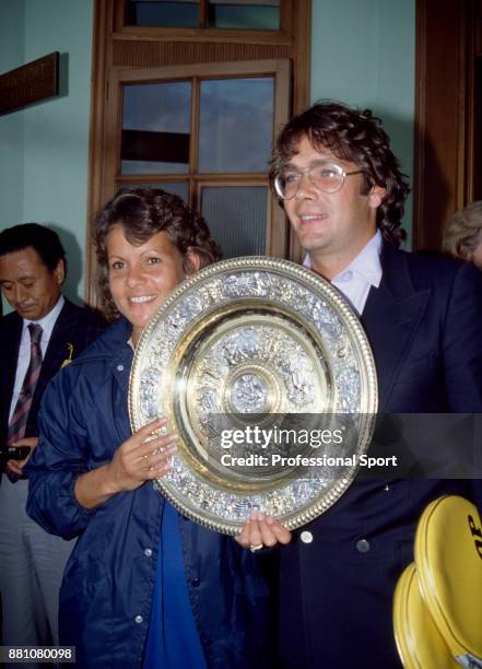 Women's Singles champion Evonne Goolagong Cawley of Australia poses with the trophy alongside her husband Roger Cawley after the Wimbledon Lawn...