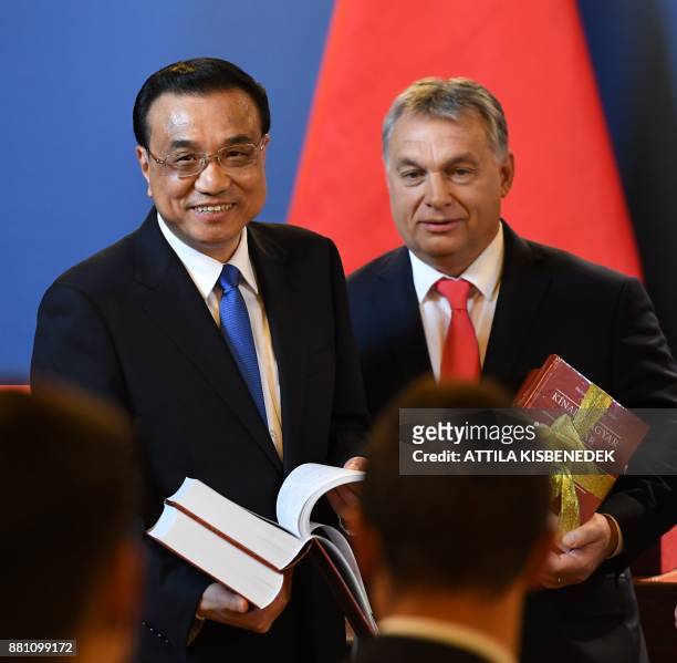 Accompanied by Hungarian Prime Minister Viktor Orban , Chinese Premier Li Keqiang receives a new edition Chinese-Hungarian dictionary after a press...