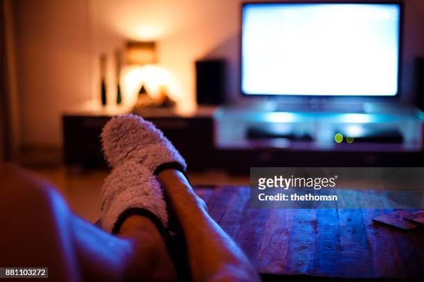 man putting feet up and watching television - feet up stock pictures, royalty-free photos & images