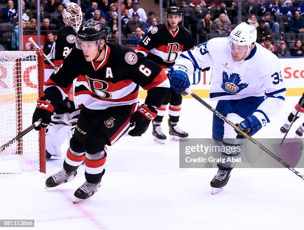 Andreas Englund of the Belleville Senators controls the puck against Frederik Gauthier of the Toronto Marlies during AHL game action on November 25,...