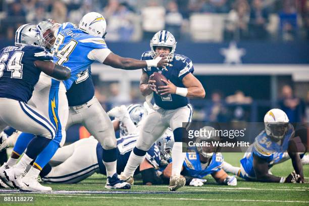 Dak Prescott of the Dallas Cowboys tries to avoid the rush from Corey Liuget of the Los Angeles Chargers at AT&T Stadium on November 23, 2017 in...