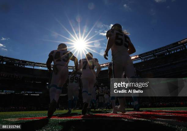 Fozzy Whittaker, Trai Turner, and David Mayo of the Carolina Panthers run onto the field against the New York Jets prior to their game at MetLife...