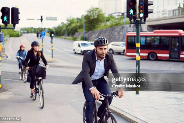 people cycling on street in city - bike work stockfoto's en -beelden