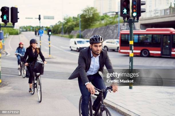 people cycling on street in city - cycle to work helmet stock pictures, royalty-free photos & images