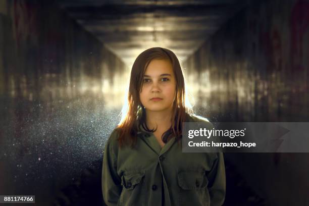 confident girl standing in a tunnel - dark background light stock-fotos und bilder