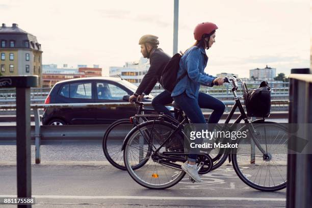 side view of people cycling on street against sky - bike work stockfoto's en -beelden