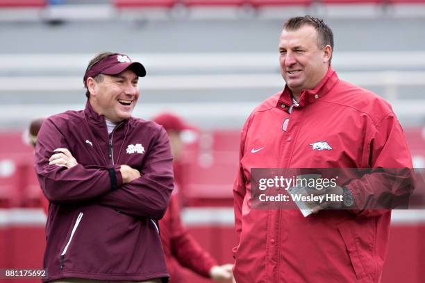 Head Coach Dan Mullen of the Mississippi State Bulldogs talks before the game with Bret Bielema of the Arkansas Razorbacks at Razorback Stadium on...