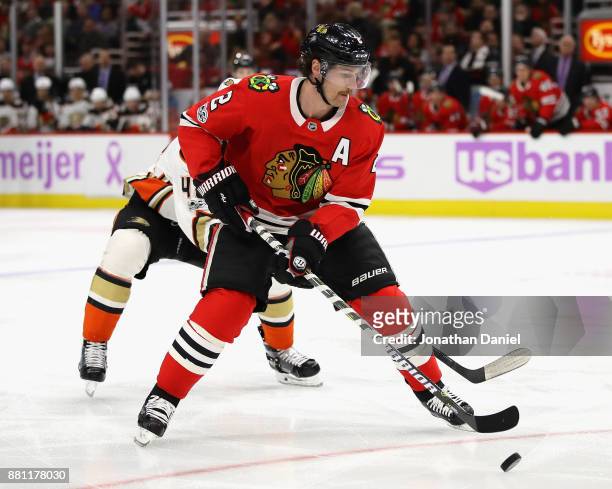 Duncan Keith of the Chicago Blackhawks chases down the puck in front of Logan Shaw of the Anaheim Ducks at the United Center on November 27, 2017 in...