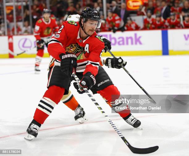 Duncan Keith of the Chicago Blackhawks chases down the puck in front of Logan Shaw of the Anaheim Ducks at the United Center on November 27, 2017 in...