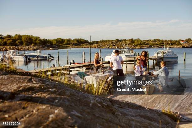 young multi-ethnic friends enjoying summer at harbor against sky on sunny day - preparazione al parto foto e immagini stock