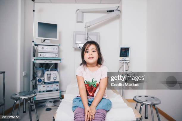 portrait of girl sitting on bed at hospital - kid sitting stock pictures, royalty-free photos & images