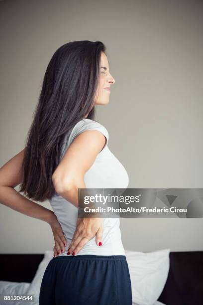 woman suffering from back pain - back pain woman stock pictures, royalty-free photos & images