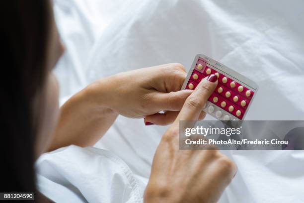 woman holding birth control pills - family planning stock pictures, royalty-free photos & images