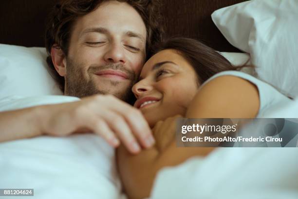 couple embracing in bed - affectionate stock pictures, royalty-free photos & images