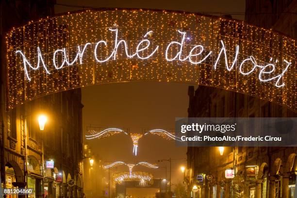 illuminated sign advertising an outdoor christmas market in arras, france - marché de noël photos et images de collection