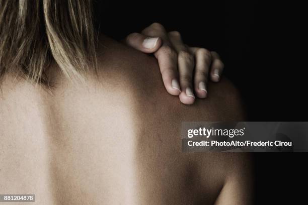 woman rubbing her bare shoulder, cropped - shoulder detail ストックフォトと画像